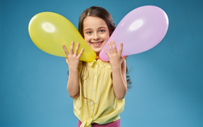 Маленькая девочка с воздушными шариками на голубом фоне