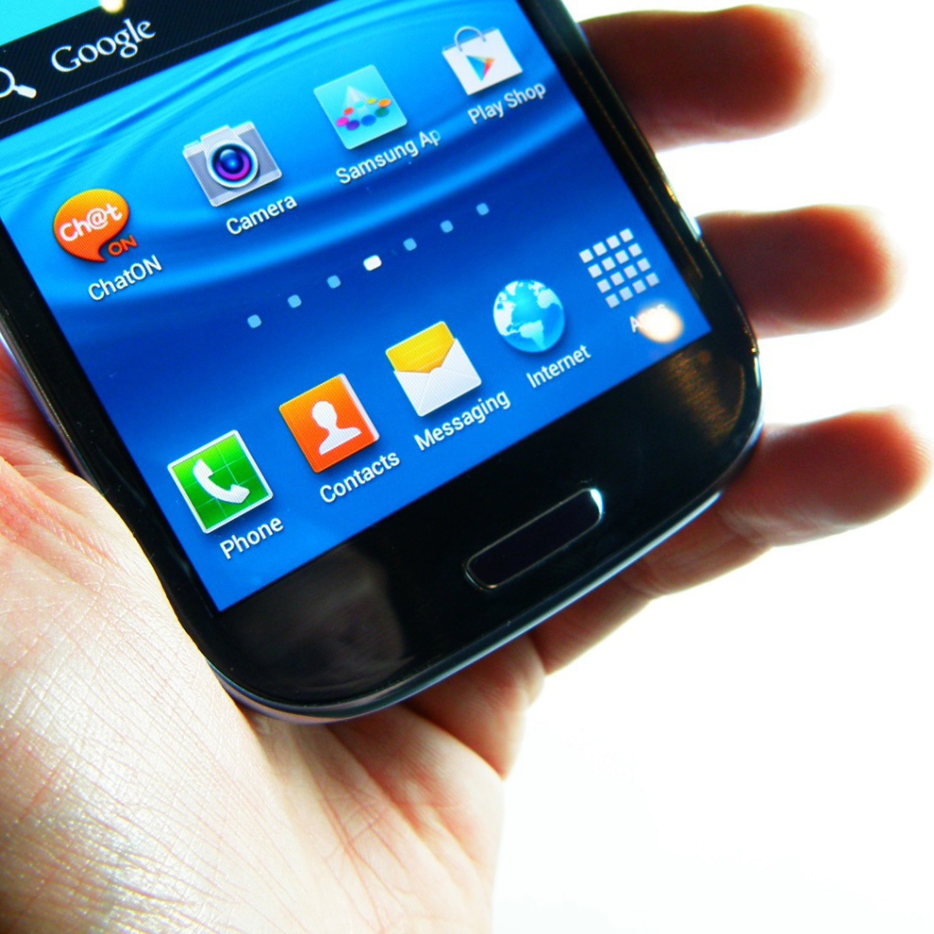 Samsung Galaxy S3 в руке на белом фоне