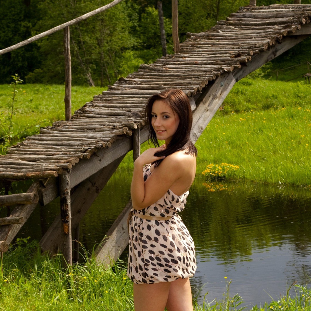 Девушка у деревянного моста через реку