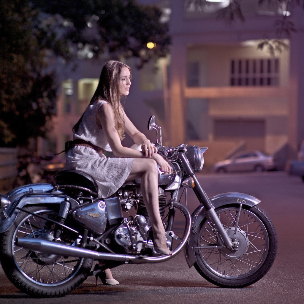 Девушка на мотоцикле стоит на парковке