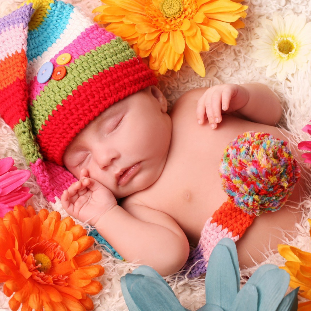 Малыш спит в постели среди цветов
