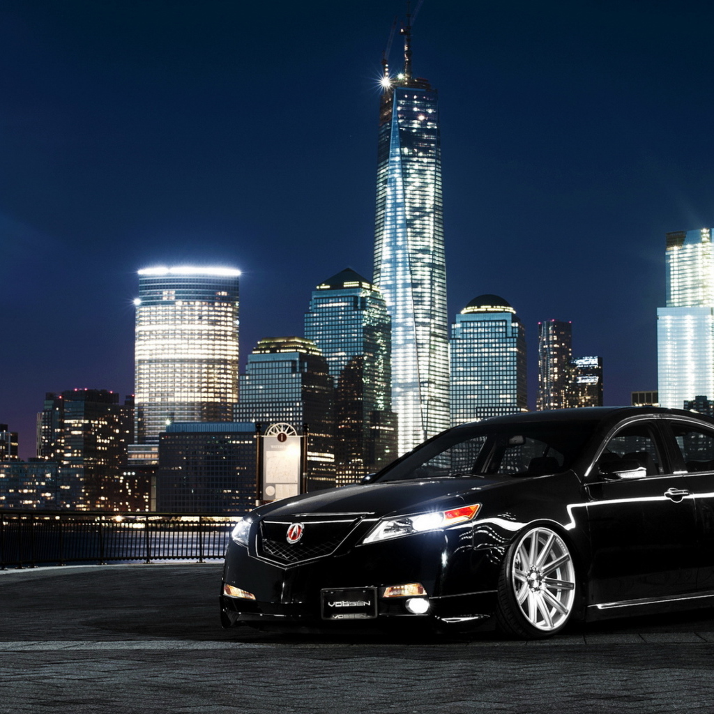 Черный автомобиль Acura TL на фоне ночных небоскребов 
