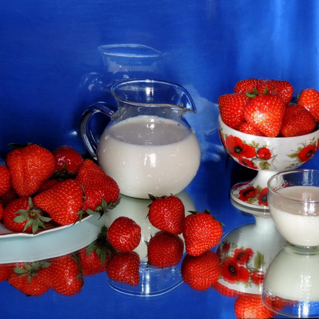 Свежие аппетитные ягоды клубники на столе с молоком
