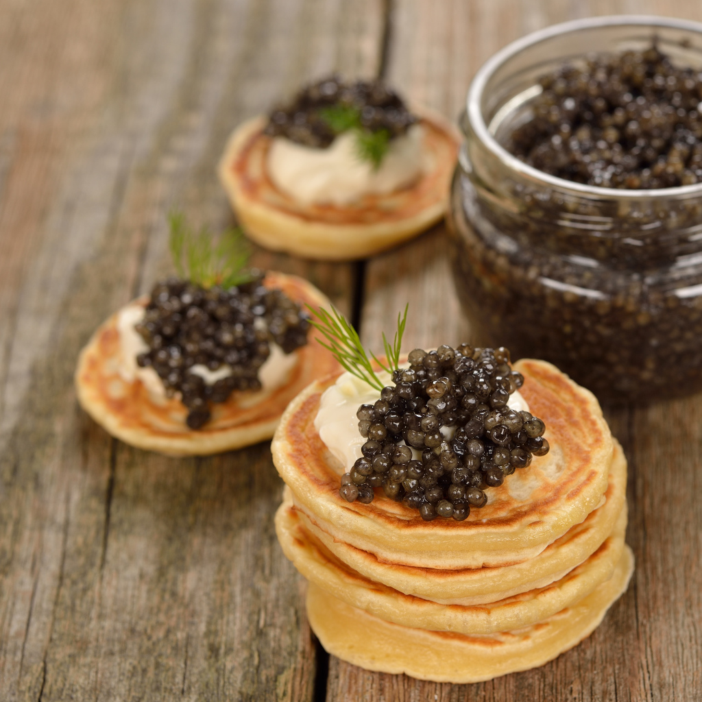 Pancakes with caviar and greens on the table