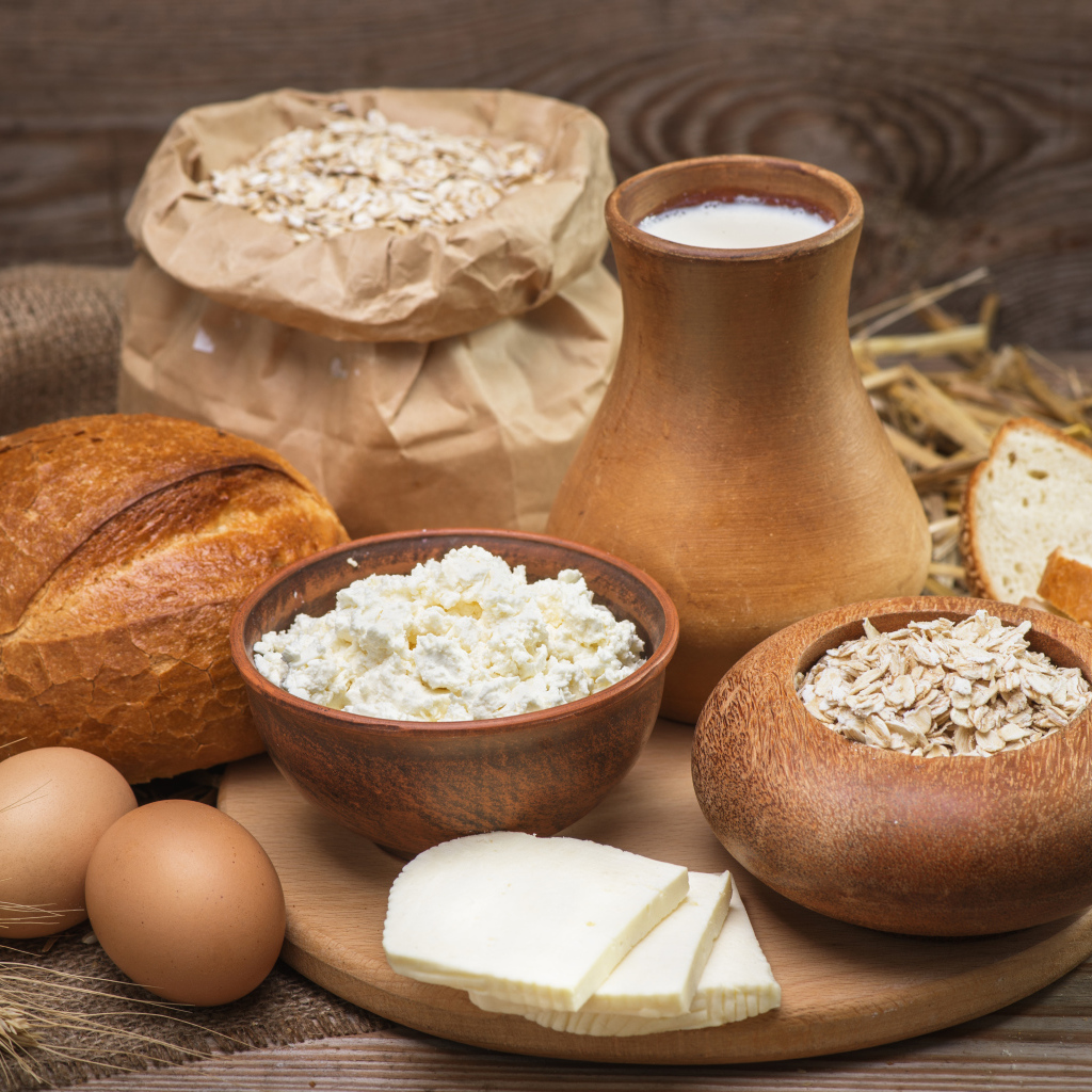 Натюрморт сыр, хлеб, яйца и молоко на столе 