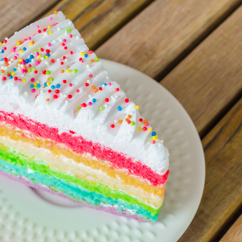 A piece of a multi-colored cake on a white plate