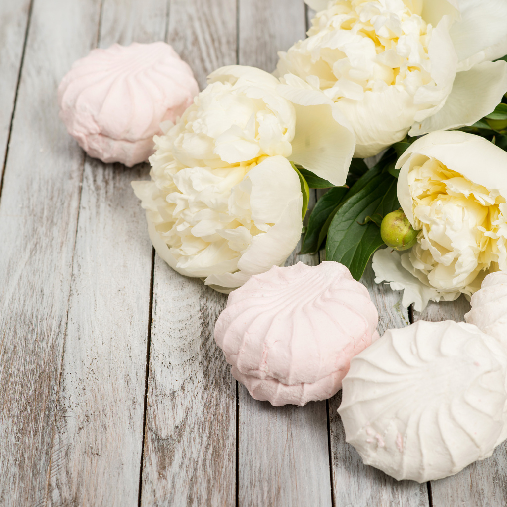 Sweet marshmallow on a table with white peonies