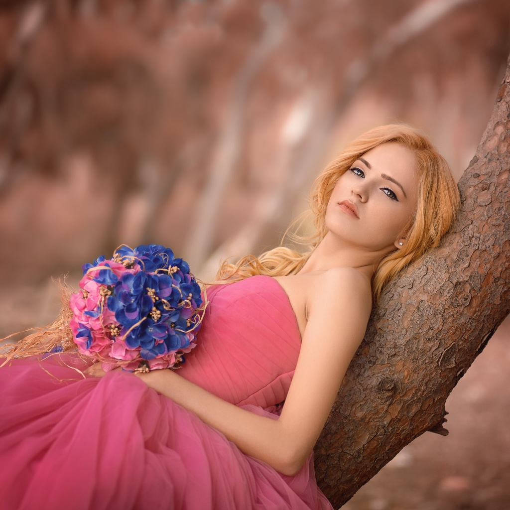 Красивая девушка в розовом платье с букетом 