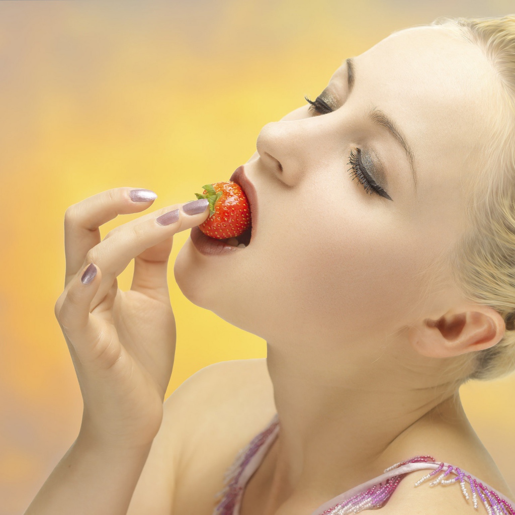 Девушка блондинка ест клубнику