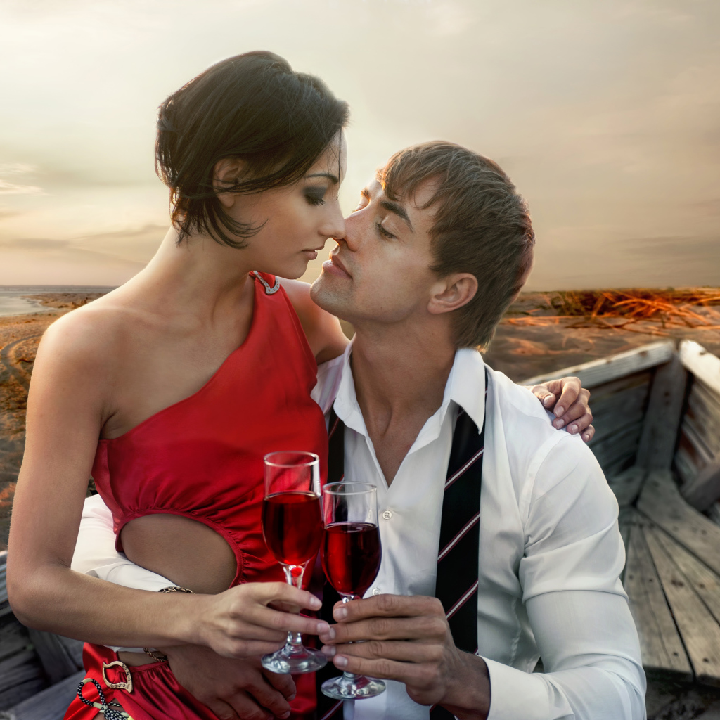 Влюбленная пара сидит в деревянной лодке с бокалами вина