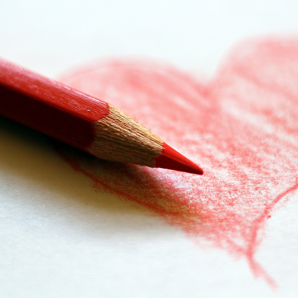Нарисованное карандашом красное сердце на бумаге
