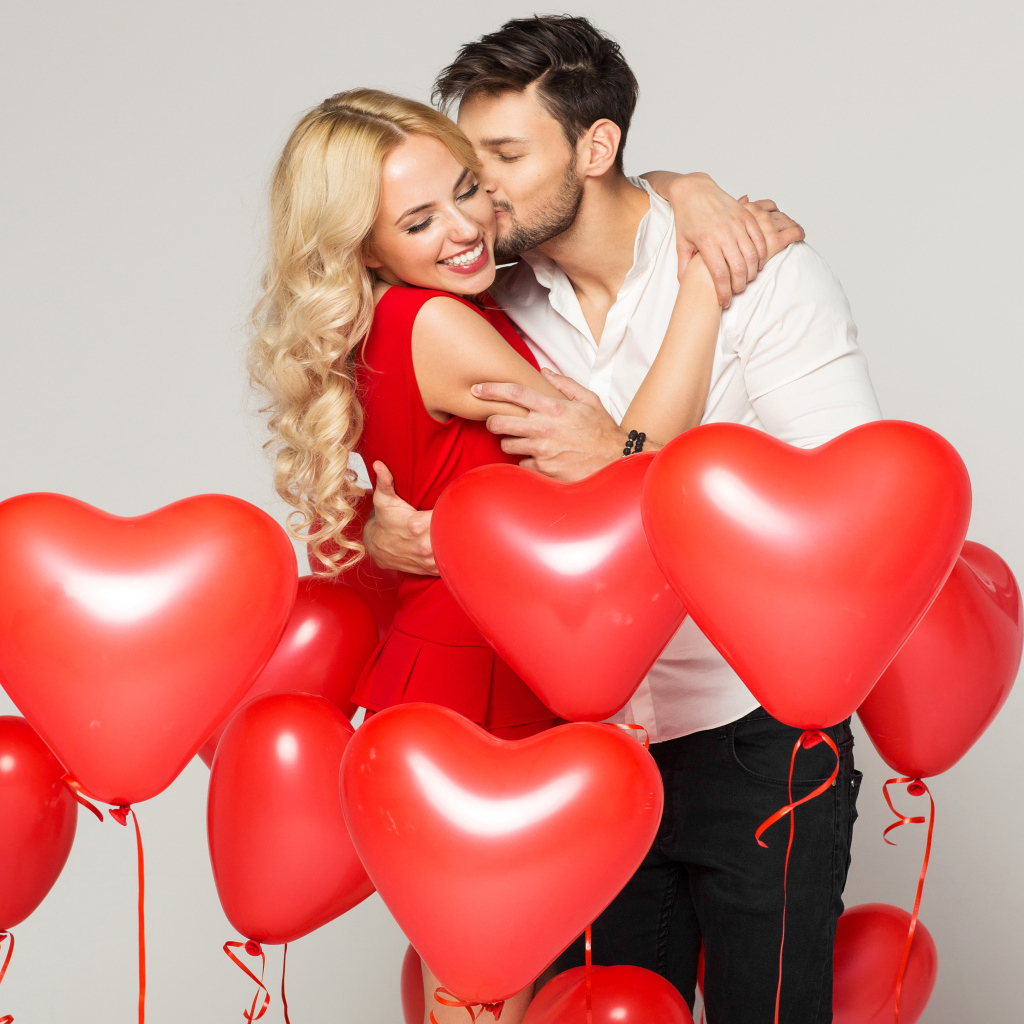 Счастливая влюбленная пара с воздушными шариками в форме сердца