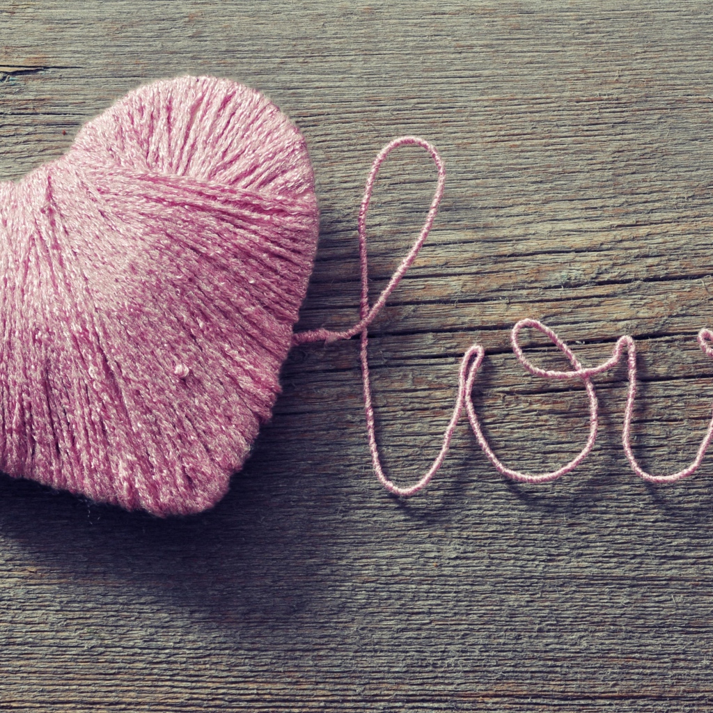 Надпись Love из розовых ниток на деревянном столе