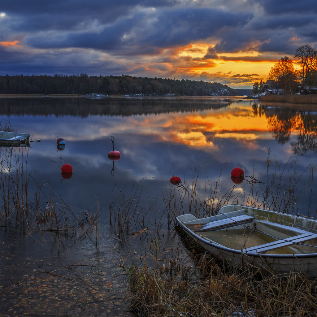 Лодки в тихом лесном озере на закате солнца