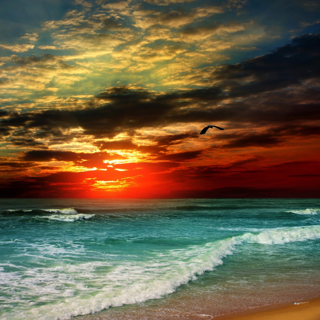 Белые волны на берегу океана на закате солнца