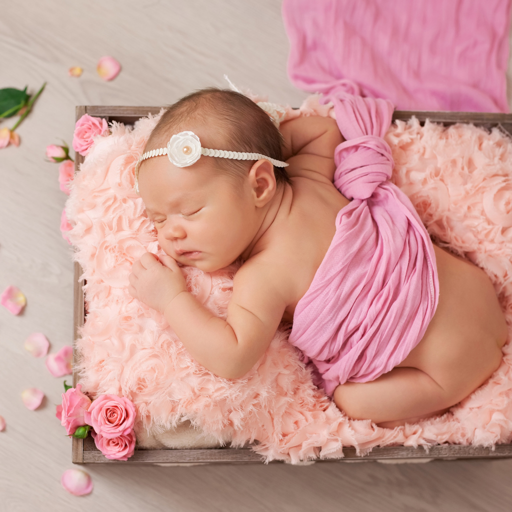 Спящий младенец с розовыми лепестками роз