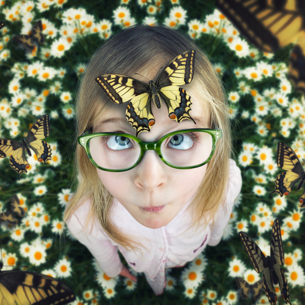 Забавная девочка в очках с бабочкой на голове