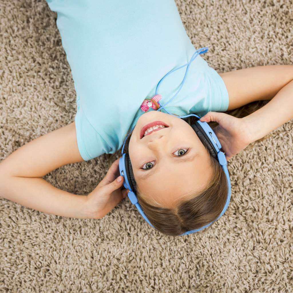 Smiling girl in big blue headphones
