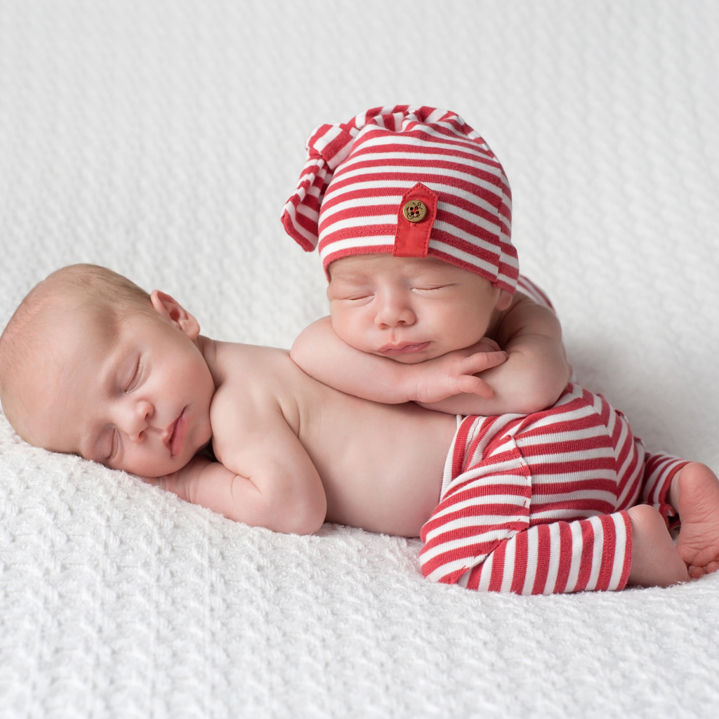 Два милых спящих младенца в полосатых костюмах