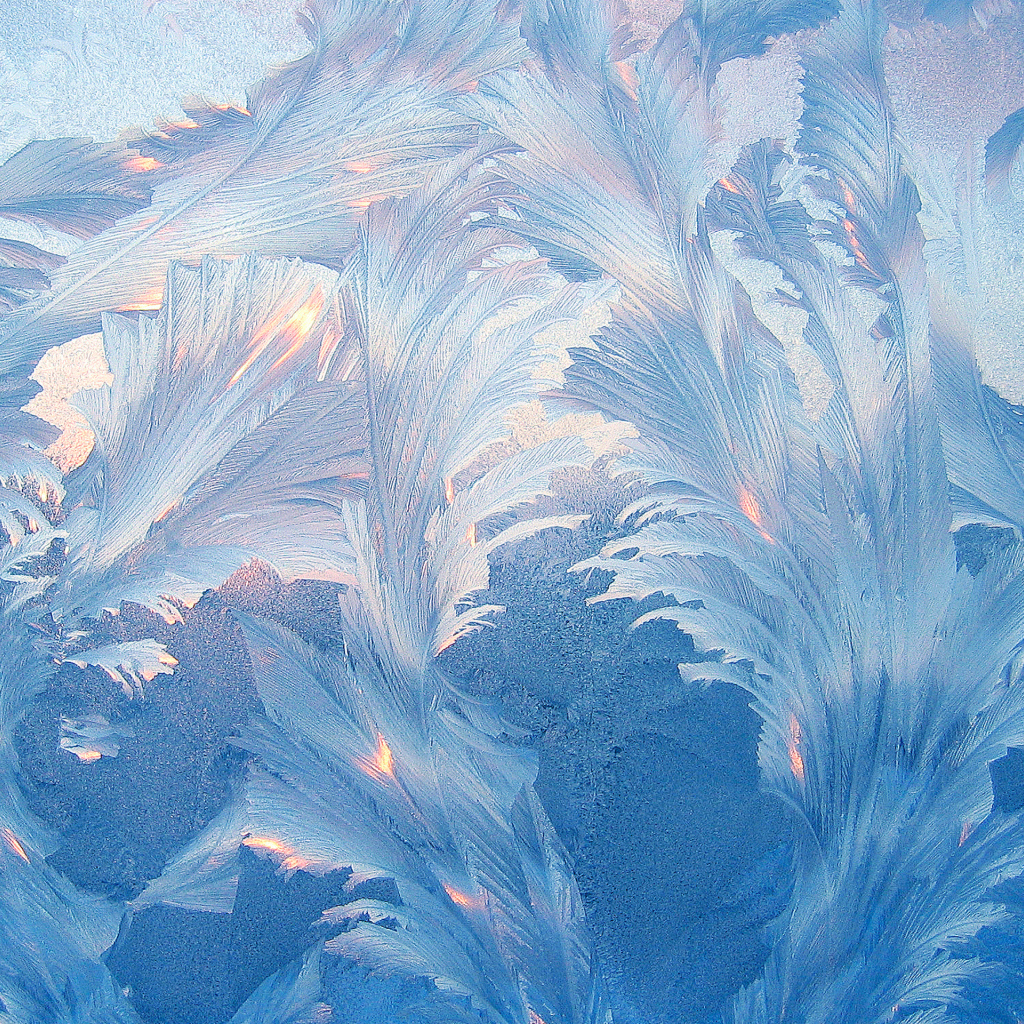 Красивые голубые морозные узоры на стекле