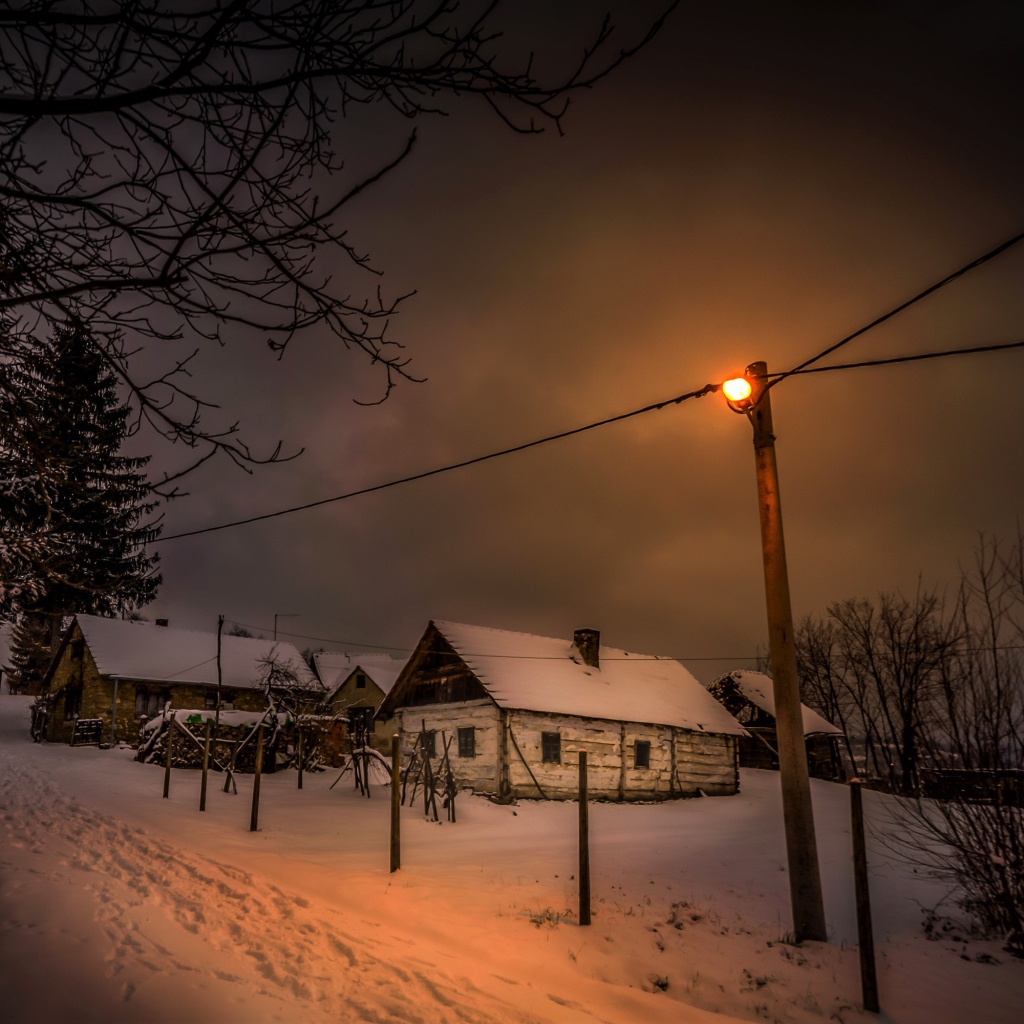 Покрытые снегом дома на зимней улице ночью