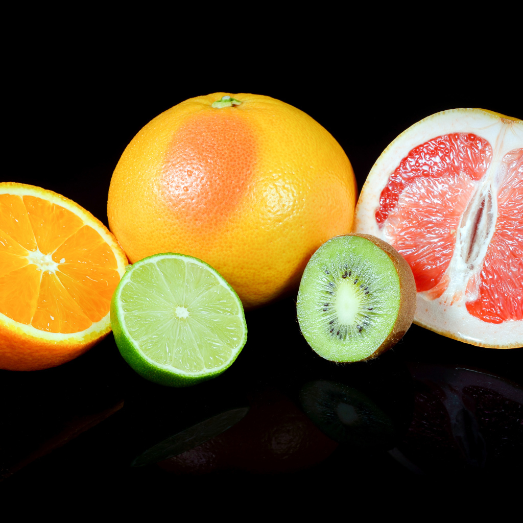 Апельсины, грейпфруты,  лайм и киви на черном фоне