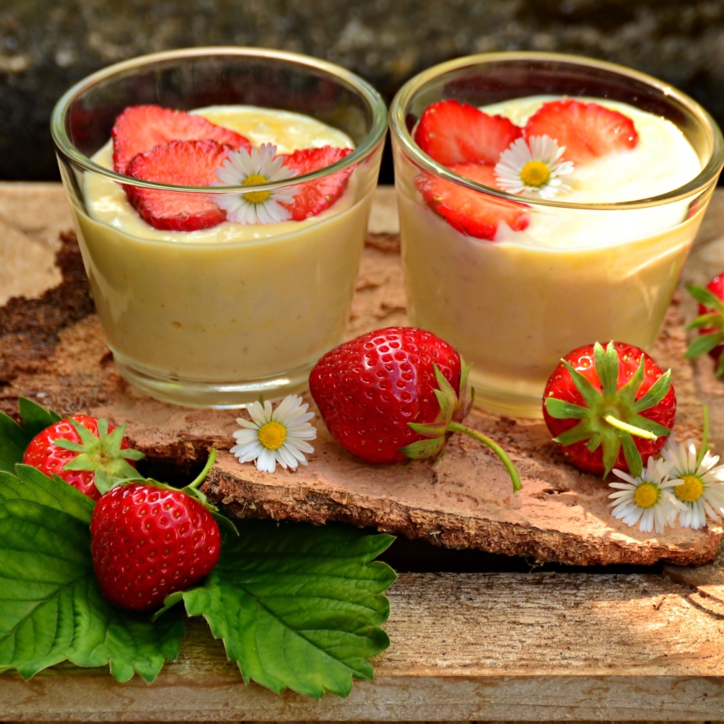 Десерт с йогуртом и свежей клубникой в стаканах на столе