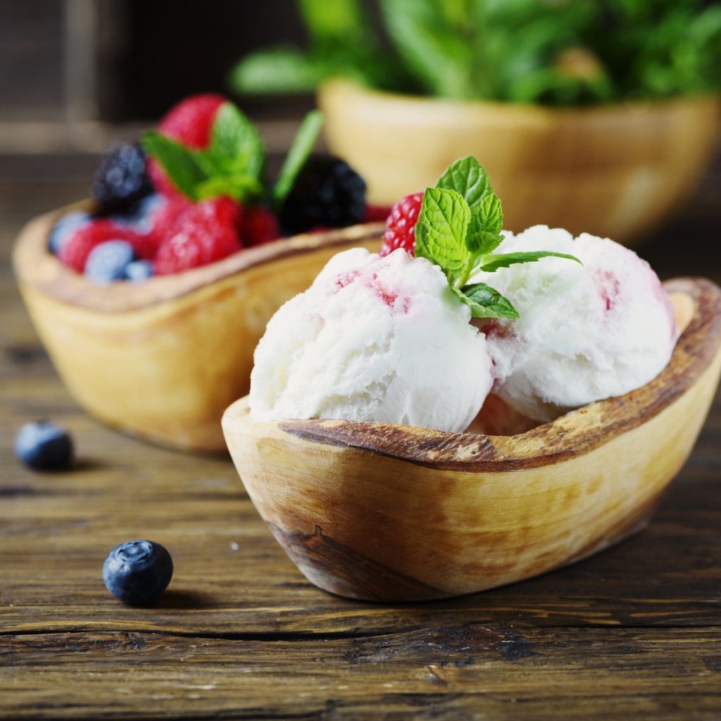 Шарики мороженого с ягодами в деревянной посуде