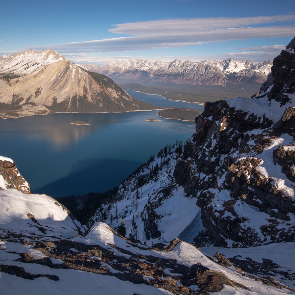 Озеро между заснеженных гор на фоне голубого неба