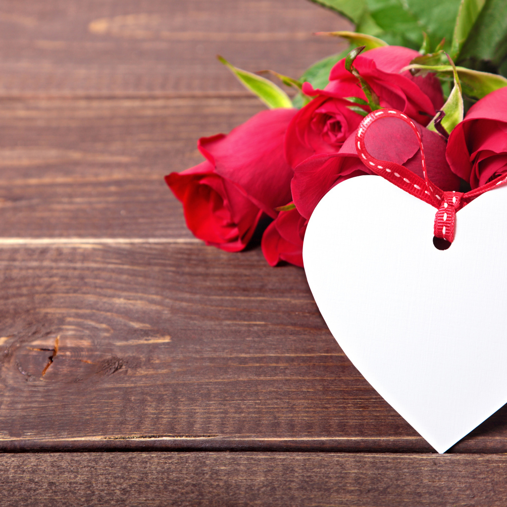 Букет розовых роз с бумажным сердцем на деревянном фоне