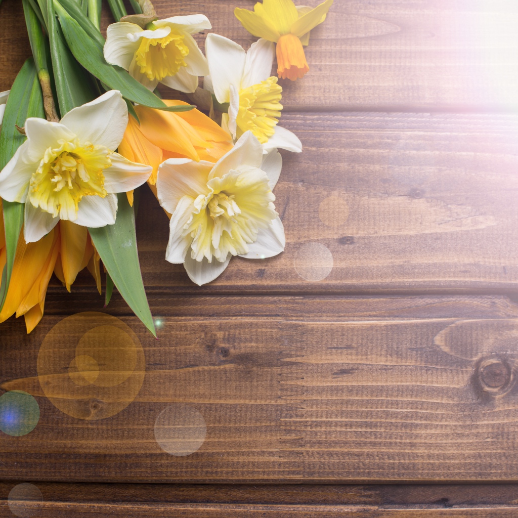 Нарциссы и желтые тюльпаны на деревянном фоне