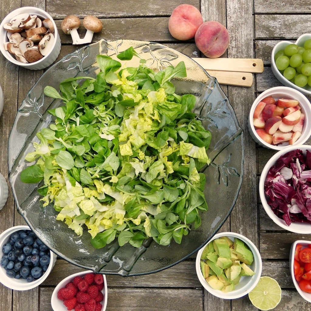 Зеленый салат на столе с ягодами и овощами