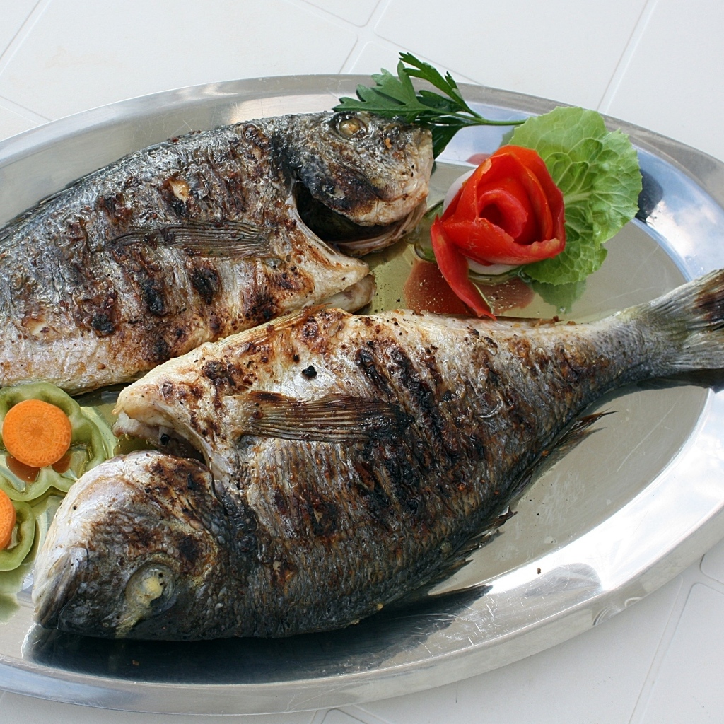 Запеченная рыба на тарелке с овощами