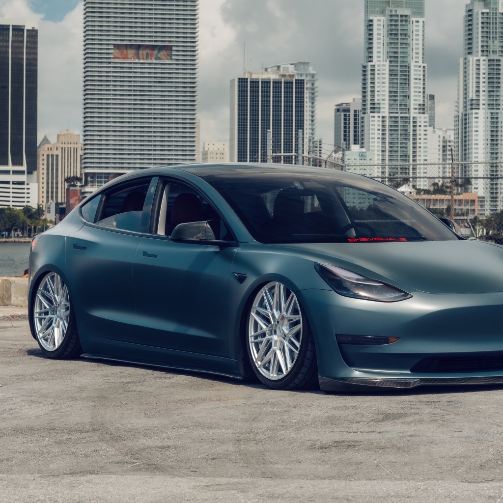 Электрокар Tesla Model 3 на фоне небоскребов