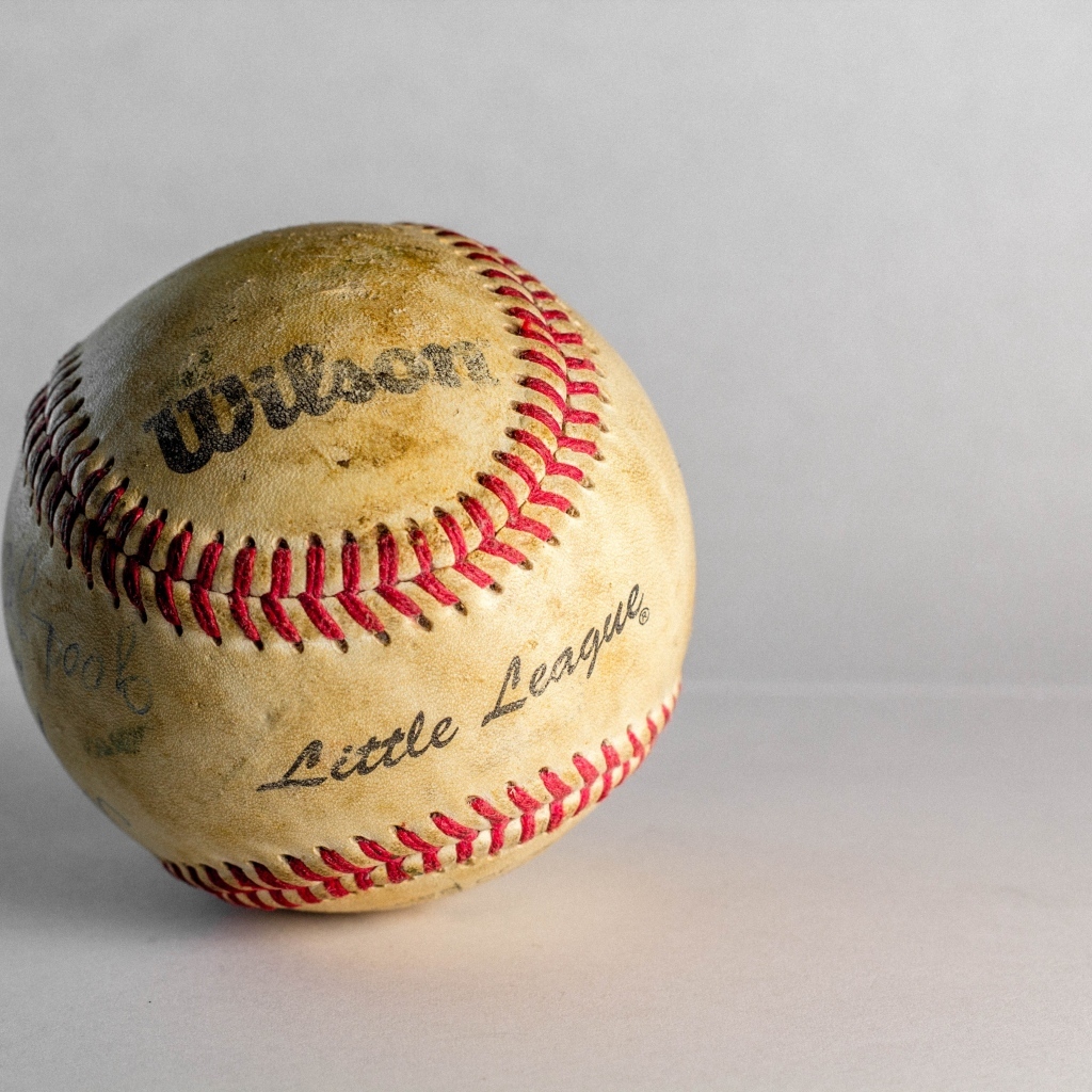 Старый бейсбольный мяч на сером фоне