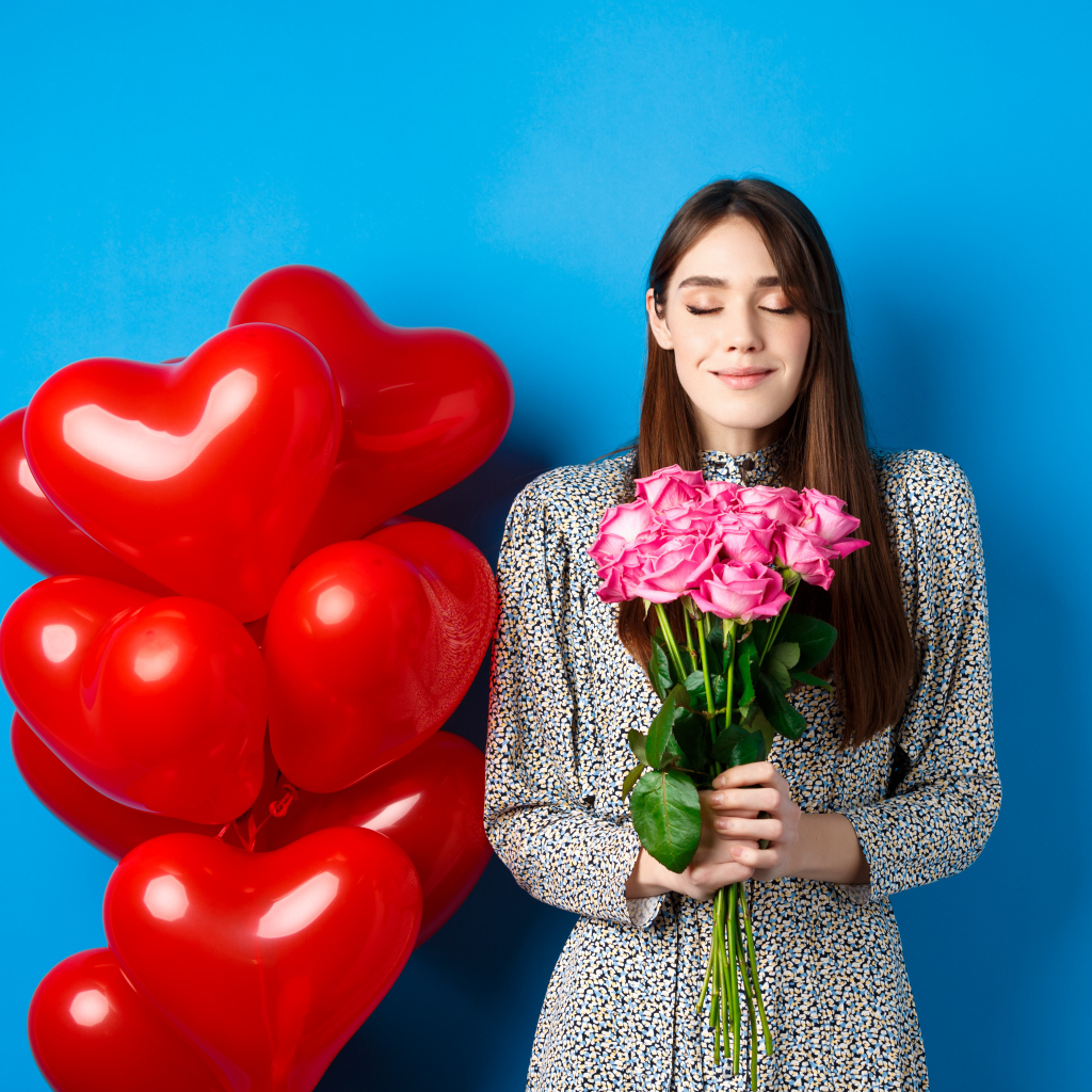 Девушка с букетом роз и воздушными шарами на день Влюбленных