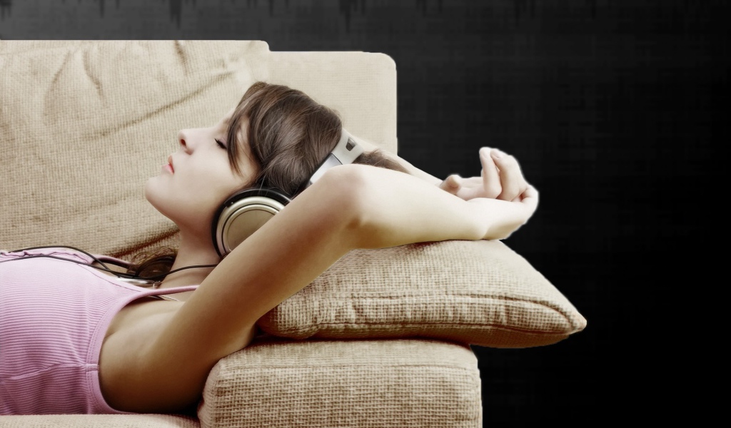 Девушка в наушниках слушает музыку