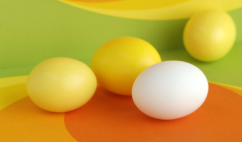 Желтые и белое яйцо на Пасху
