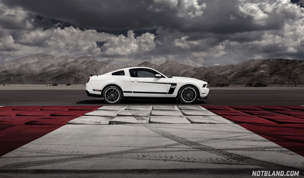 Белый Ford Mustang на фоне гор и облаков