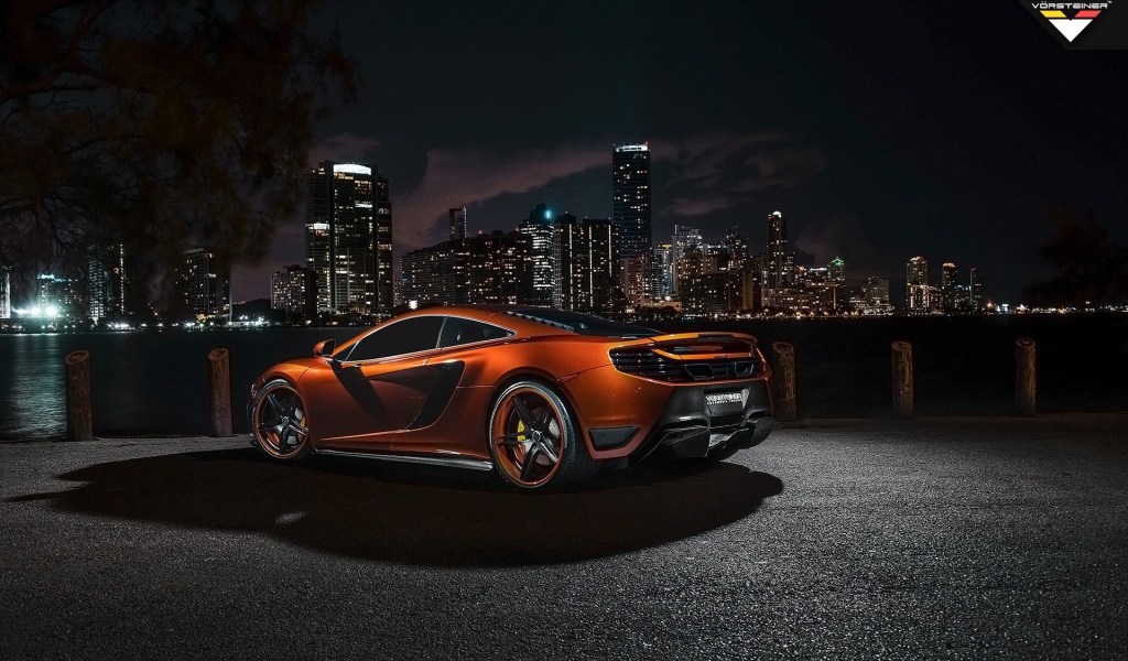 Orange McLaren MP4-12C against the backdrop of the city at night