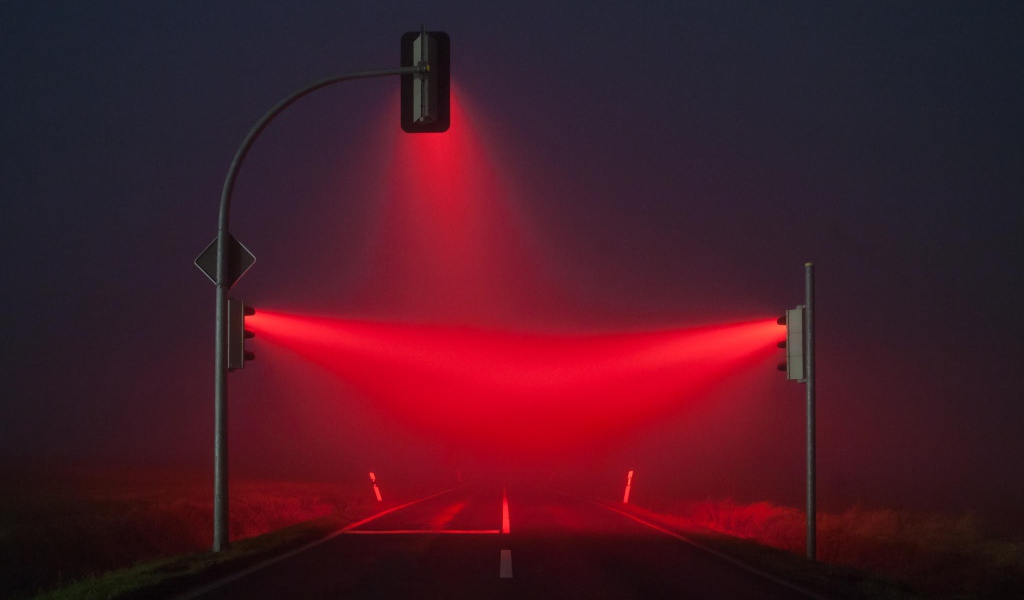 Красные светофоры освещают туман