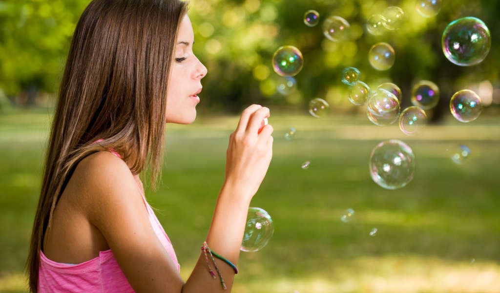 Девушка играет с мыльными пузырями