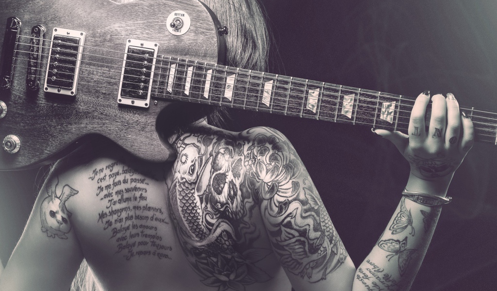 Гитара на спине татуированной девушки