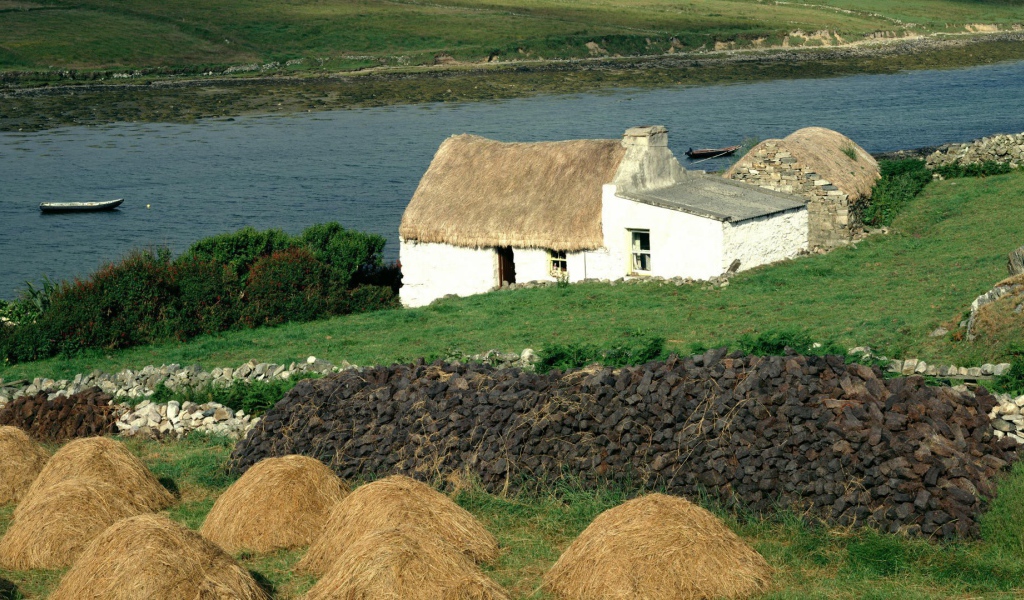Покрытый соломой дом на берегу реки