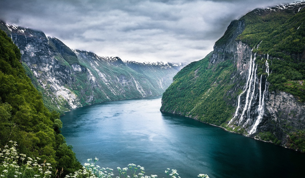 Water flows from a cliff into the fjord