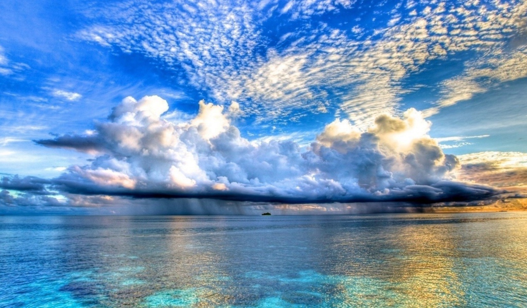 Разные облака над островком в океане