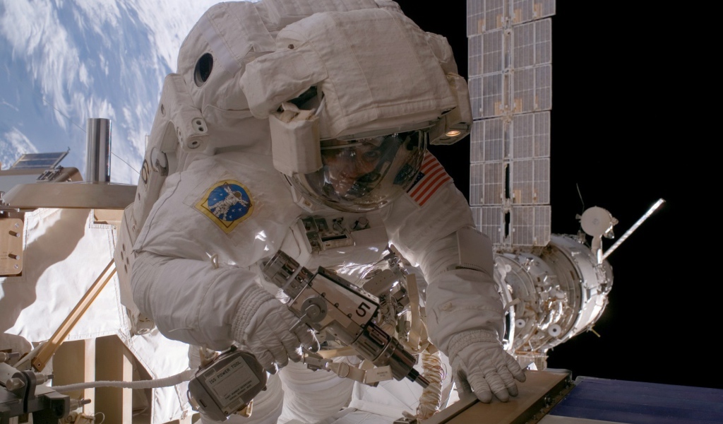 Космонавт на орбите выполняет ремонт