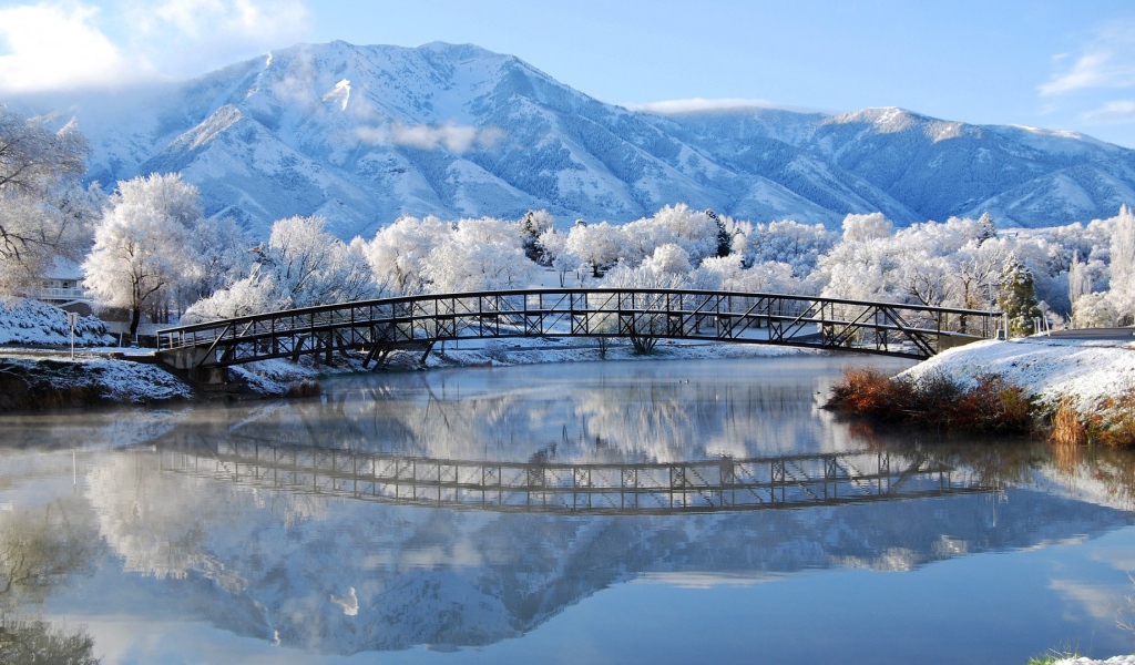 Мост через зимнюю реку в горах