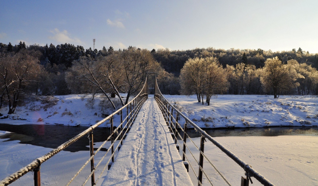 Следы на снегу на мосту через реку