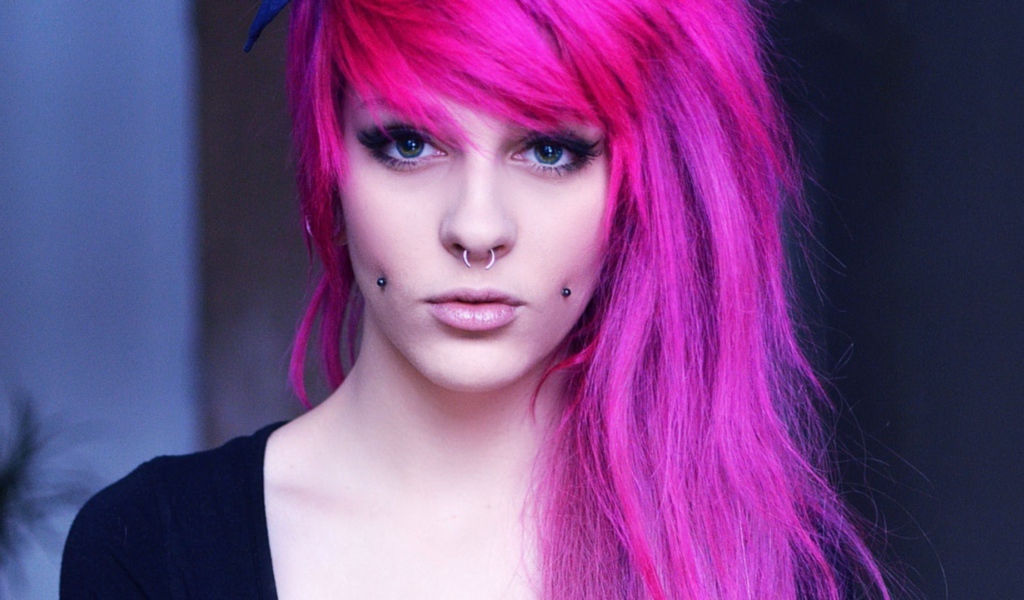 Девушка с розовыми волосами и пирсингом в щеках